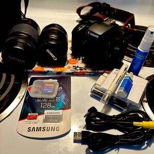 Canon camera with 2 lenses, a bag with cords, cleaner and extra SD cards